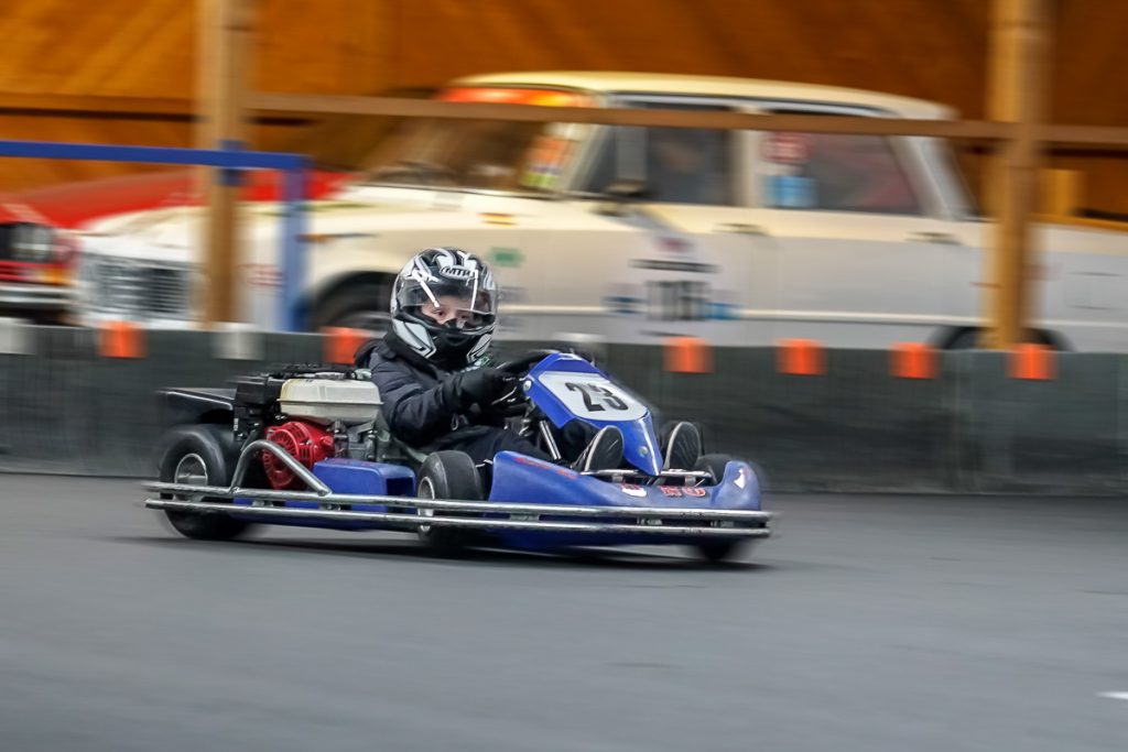 Kartfahrer in einem blauen Kart auf der Kartbahn
