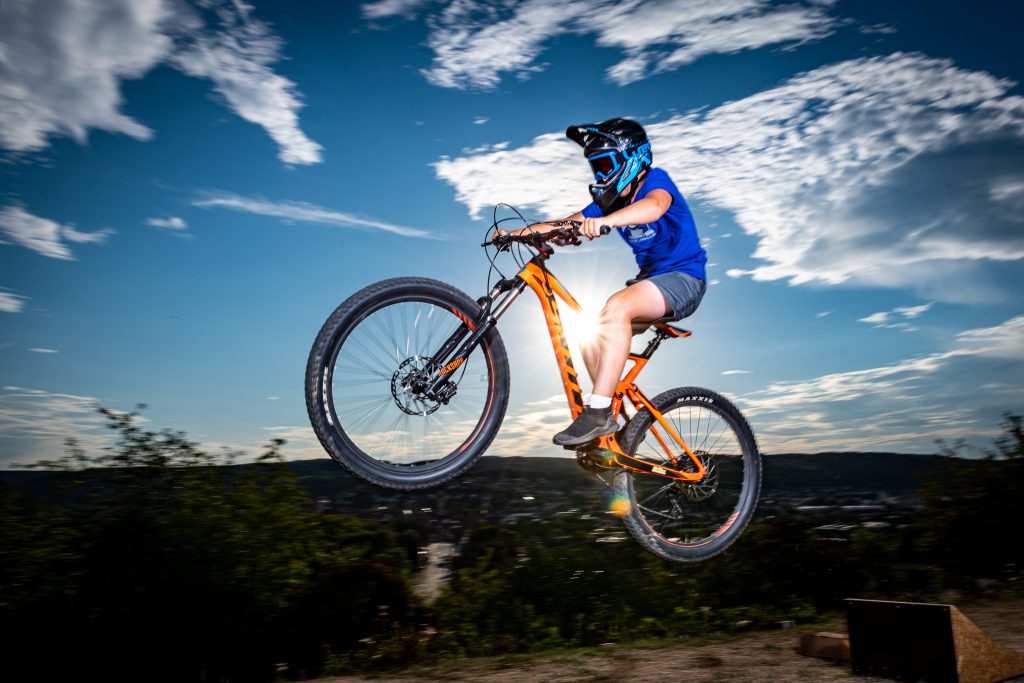 Mountainbiker im Sprung vor blauem Himmel