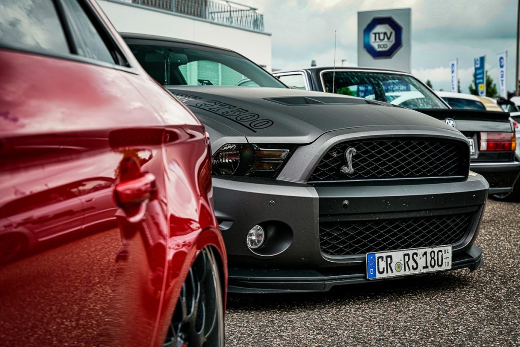 Roter Wagen und grauer Ford Mustang nebeneinander