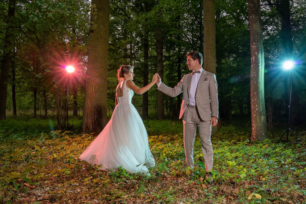 Brautpaar im Wald mit bunten Lichtpunkten im Hintergrund