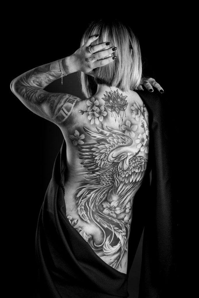 Frau von hinten mit großem Rückentattoo, Schwarzweißaufnahme