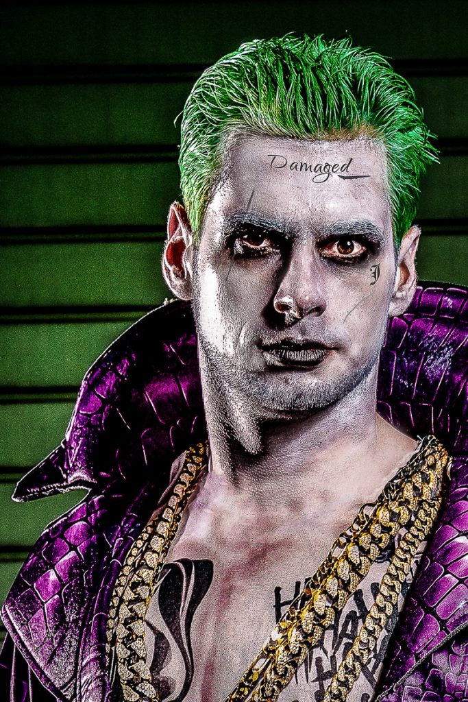 Porträt eines Mannes mit grünen Haaren und Schminke im Joker-Look